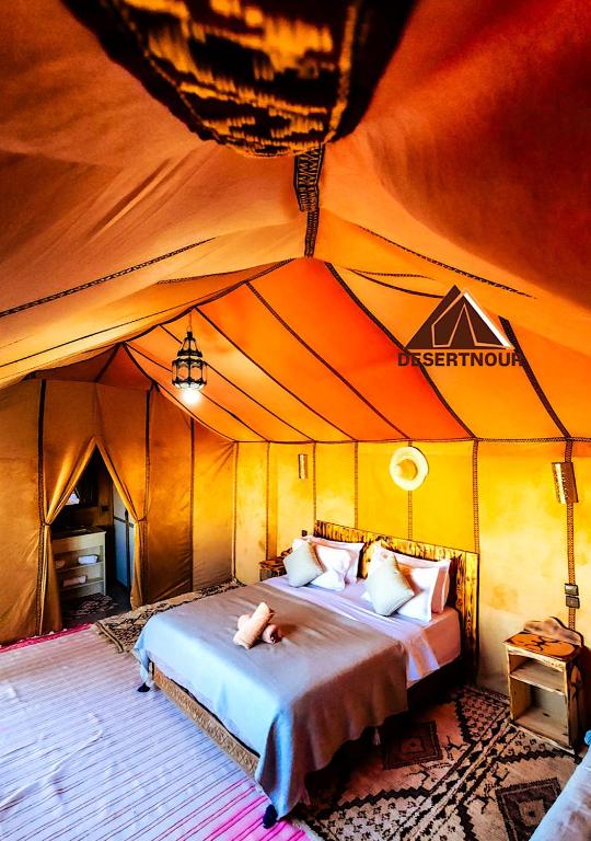 a bedroom with a bed in a tent at Nour Desert Luxury Camp in Merzouga