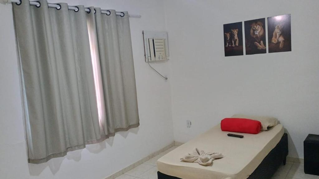 a room with a bed and a window with curtains at Apartamento Brisa 202 in Pedra de Guaratiba