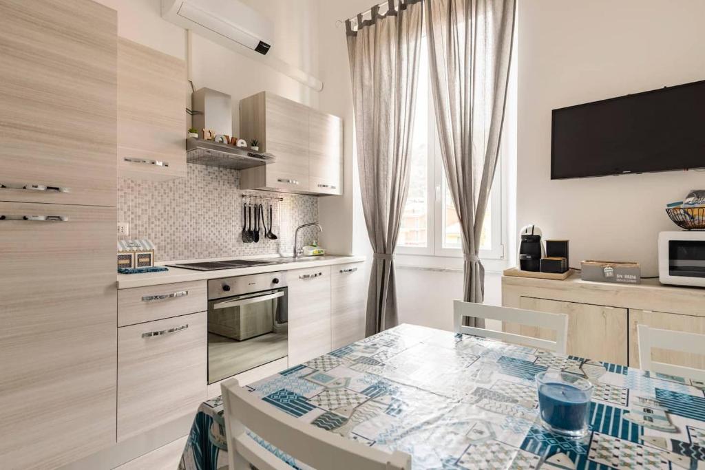 a white kitchen with a table and a microwave at Leo Holiday Homes in Deiva Marina