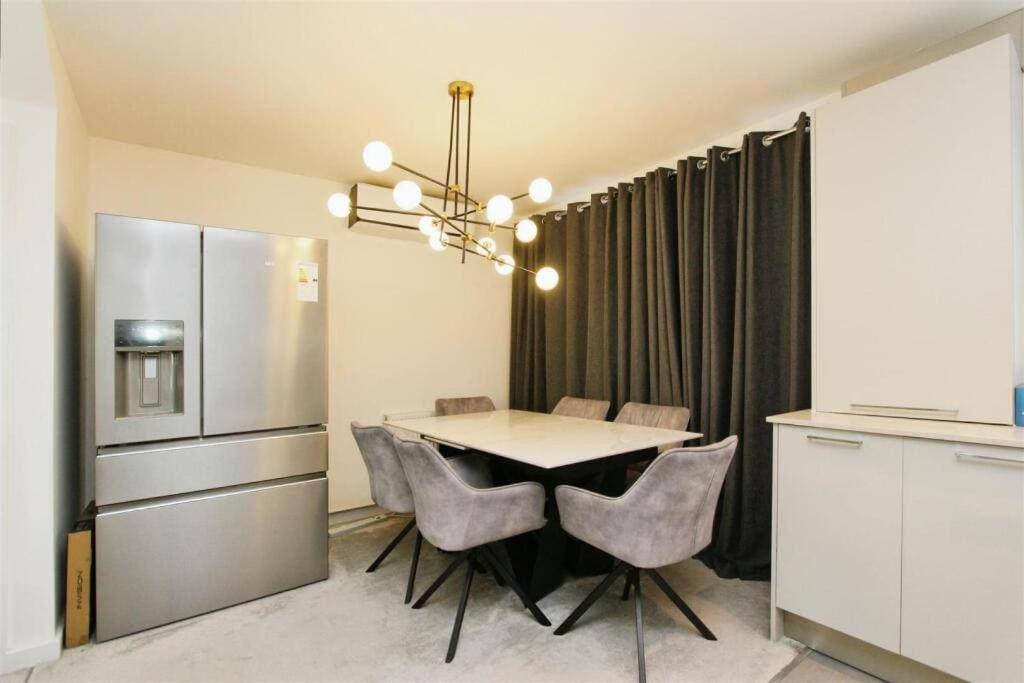 GreenhitheにあるFamily Friendly 4-Bedroomsのテーブルと椅子、冷蔵庫のあるキッチン