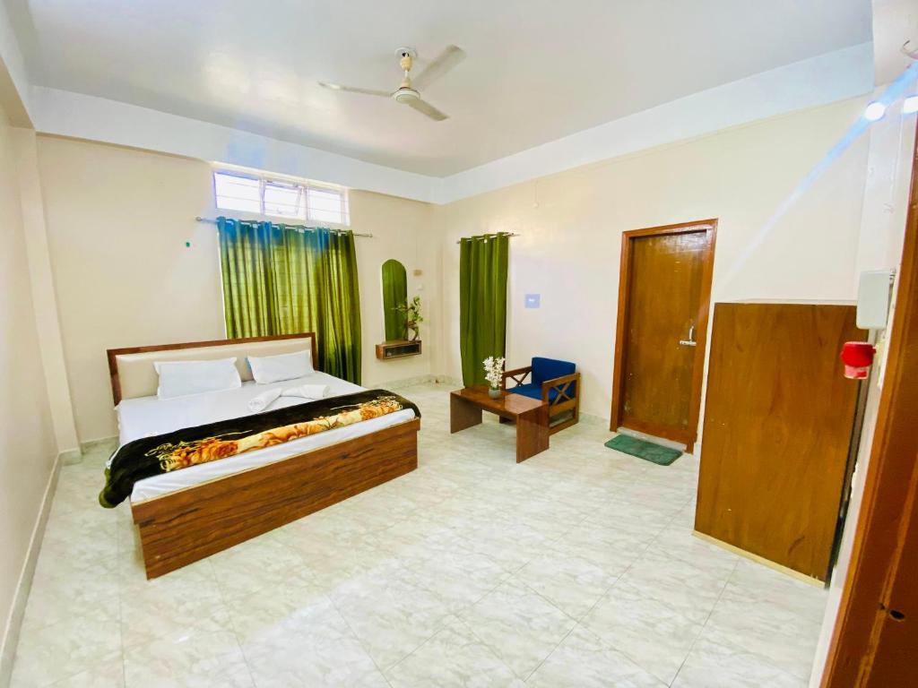 a bedroom with a bed and a window with green curtains at JM Suites Prasanti Hotel in Helāpākari