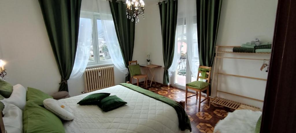 a bedroom with a bed with green pillows on it at Tirano Express Comfort 2P Appartamento spazioso con vista montagne, ideale per famiglie e gruppi in Tirano