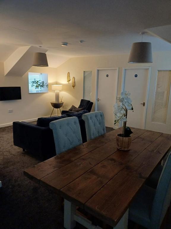 a living room with a wooden table and a couch at The Retreat Holywell in Holywell