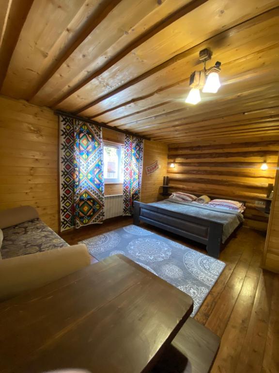 Una habitación con dos camas y un sofá en una cabaña. en Сімейний номер 2 Садиба У Ані, en Synevyrsʼka Polyana