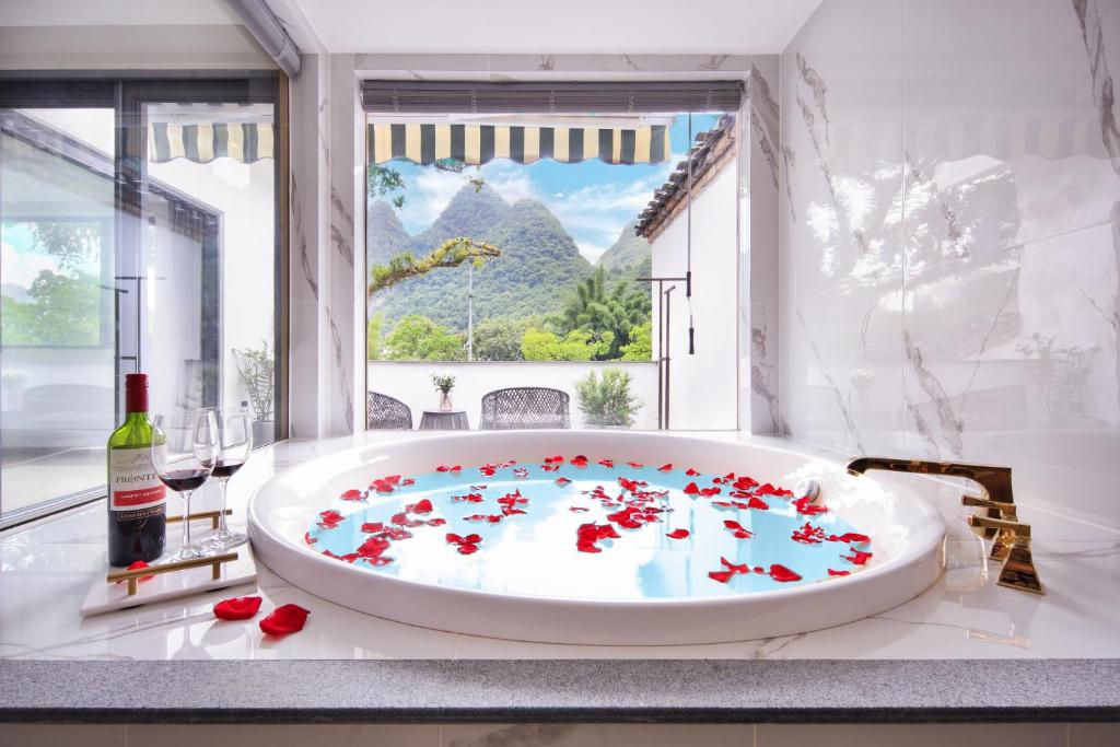 Hotel Del Moon في يانغتشو: حمام مع حوض استحمام مليء بالورود الحمراء