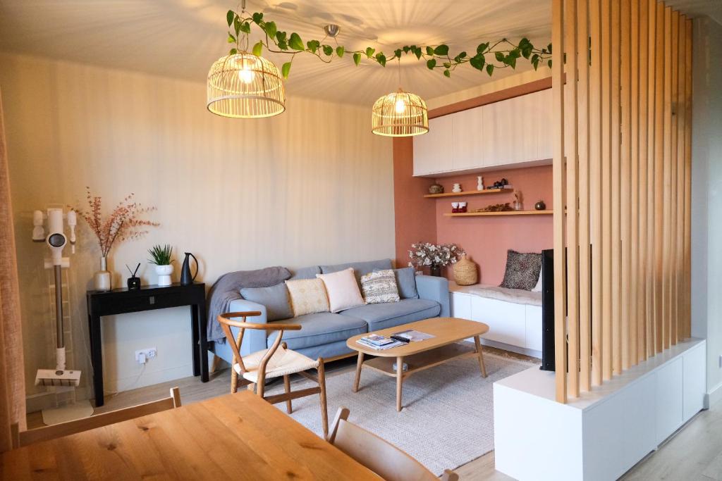 un salon avec un canapé bleu et une cheminée dans l'établissement Appartement 2 Queenbed parking clim wifi, à Aix-en-Provence