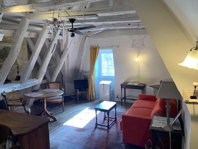 a living room with a red couch and a table at Loft Montaigne Cité médiévale Sarlat in Sarlat-la-Canéda
