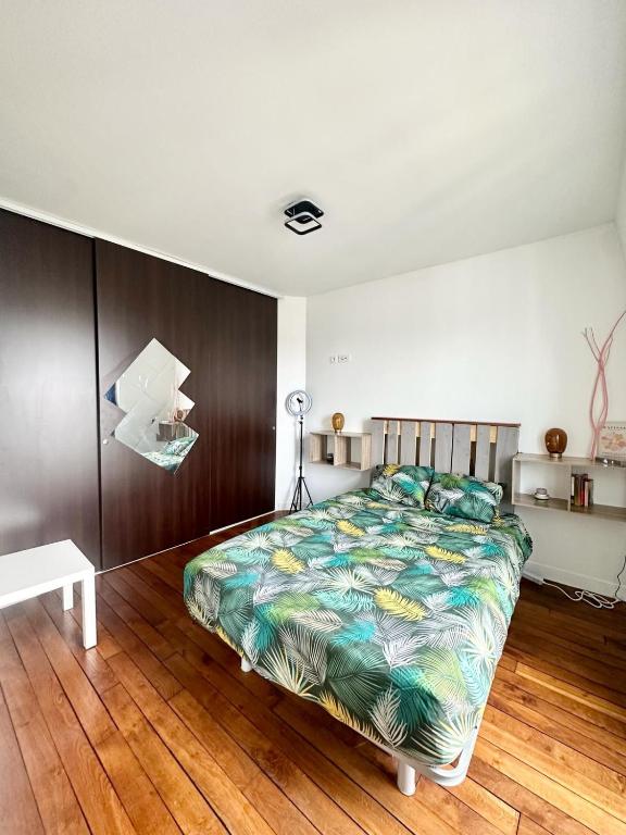 une chambre avec un lit et un parquet dans l'établissement Private apartment 2 minutes from Zenith de Paris, à Paris