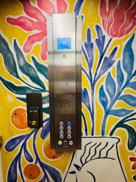 a bathroom stall with a push button elevator with a colorful wall at Hôtel Gabriel in Menton