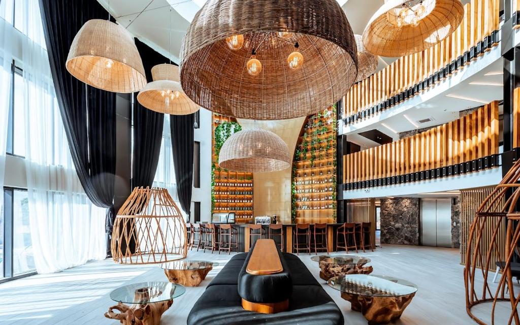 a lobby with large chandeliers and tables and chairs at Yarden Estate Hotel in Yesod Hamaala