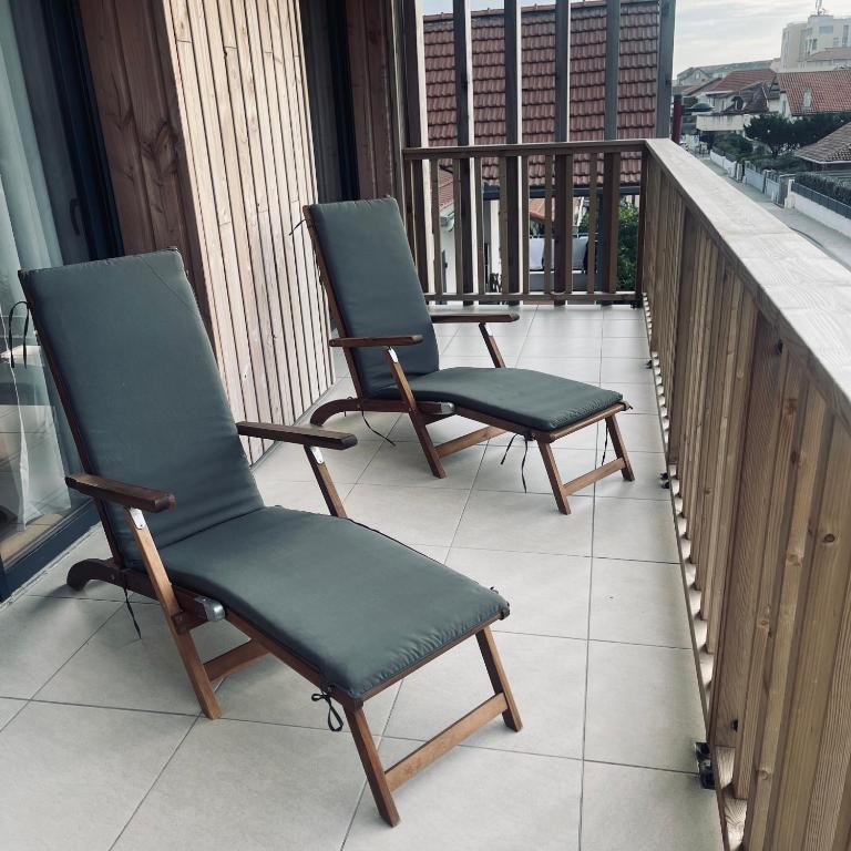 two chairs sitting on top of a balcony at F3 à mimizan plage in Mimizan-Plage