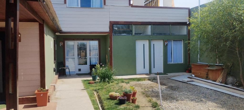 a green house with a door and some plants at Freedom GALLE in Río Gallegos