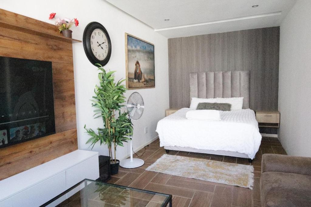 a bedroom with a bed and a clock on the wall at senator park in Cape Town
