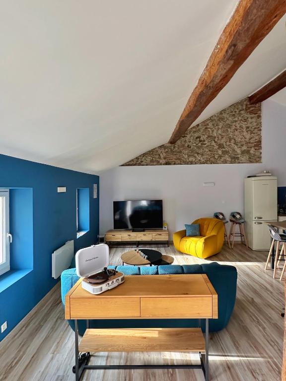 - un salon avec des murs bleus et un canapé bleu dans l'établissement Le Loft des toits de Vernet, à Vernet-les-Bains