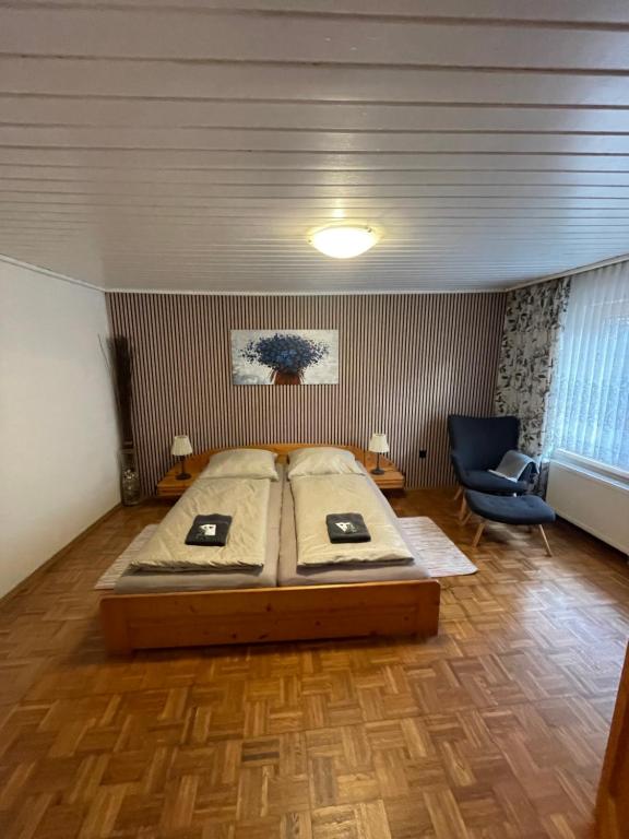 a bedroom with a large bed and a blue chair at Ferienhaus Karin in Schönabrunn