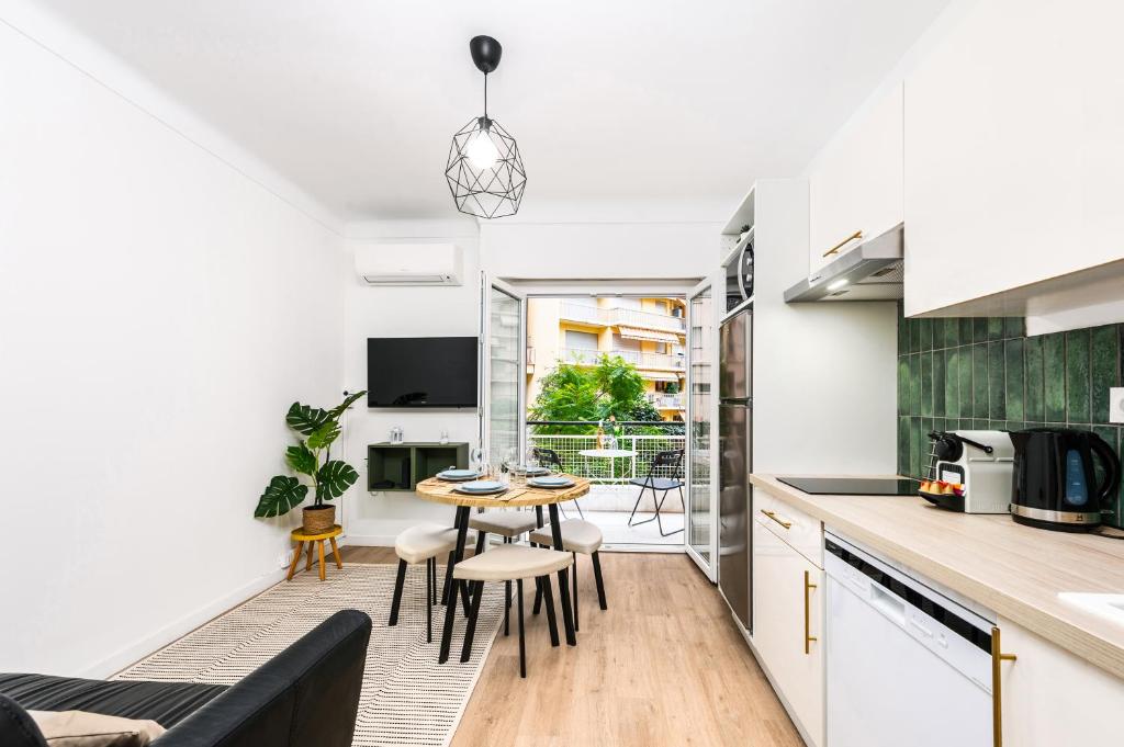 une cuisine et un salon avec une table et des chaises dans l'établissement CASTEL II - Agréable deux pièces - Menton Centre, à Menton