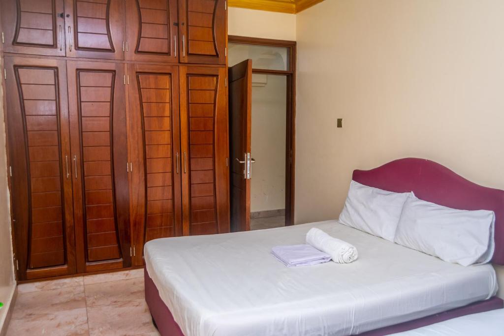 a bedroom with a bed with two towels on it at TWO BEDROOM Delamere Apartment in Mombasa
