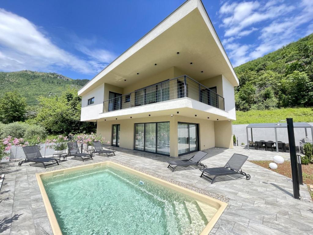 a house with a swimming pool in front of a house at Villa Perla in Mošćenička Draga