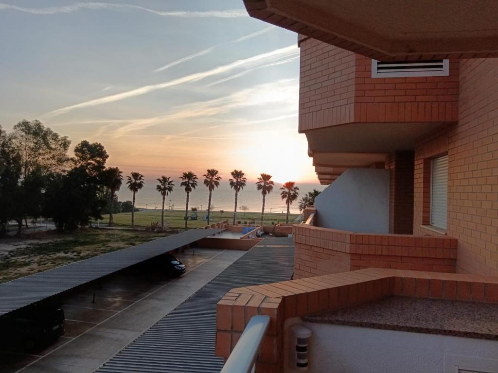 a balcony of a building with a sunset in the background at Apartamento Giovanni - Marina D'Or in El Borseral