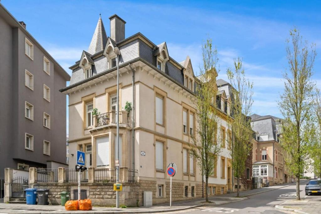 un grande edificio con torretta su strada di Spacious & Tranquil Rooms in Limpertsberg a Lussemburgo