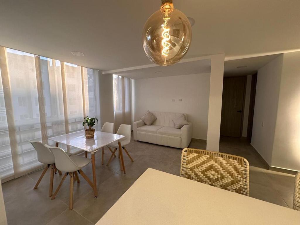 バランキージャにあるModern new apartment in Barranquillaのテーブルと椅子とソファのあるリビングルーム