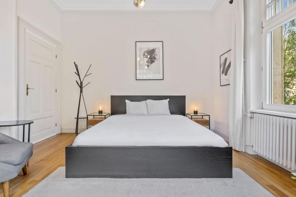 una camera da letto con un grande letto bianco e una finestra di Spacious & Tranquil Rooms in Limpertsberg a Lussemburgo