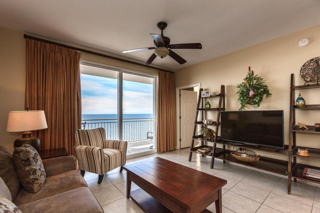 Una sala de estar con un sofá, un televisor y una mesa. en Splash Ocean-front Luxury Two-bedroom Beach Condo, en Panama City Beach