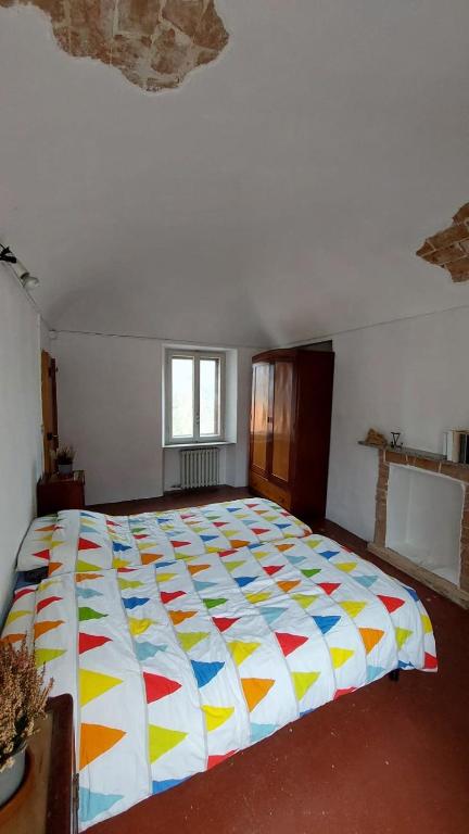 ein Schlafzimmer mit einem großen Bett mit einer bunten Bettdecke in der Unterkunft iris in Coggia