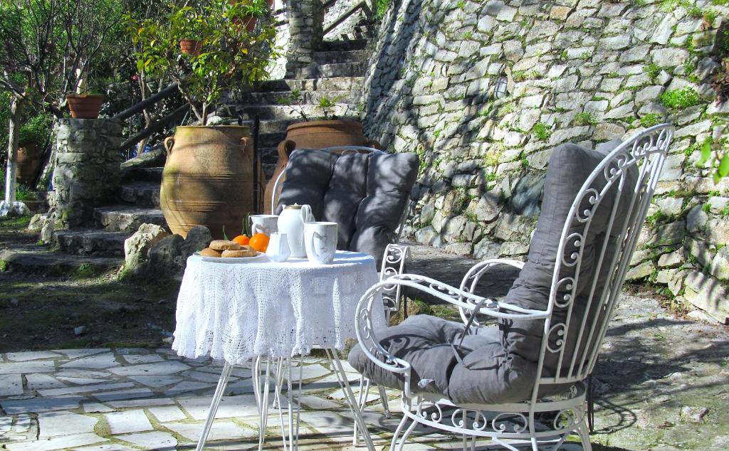 a table and two chairs with a white tablecloth on it at Angela's River Paradise Cottages in Mixórrouma