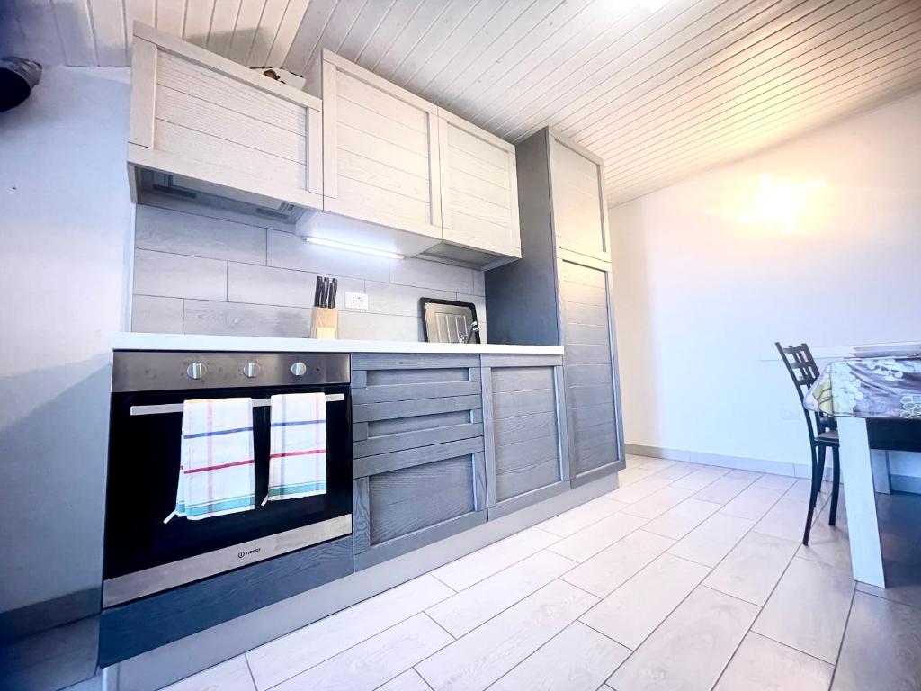 a kitchen with a stove and cabinets and a table at Uno Due Tre Stella in Chioggia