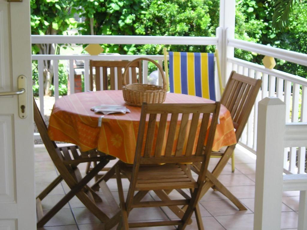 a table and two chairs on a porch at L'escapade in Sainte-Anne