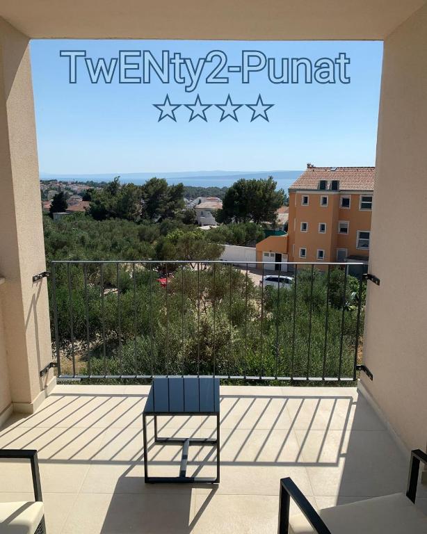 a blue chair on a balcony with a view at TwENty2-Punat Apartments in Punat