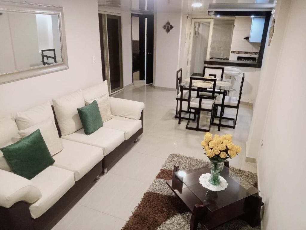 a living room with a white couch and a table at Hogar del Bosque in Nobsa