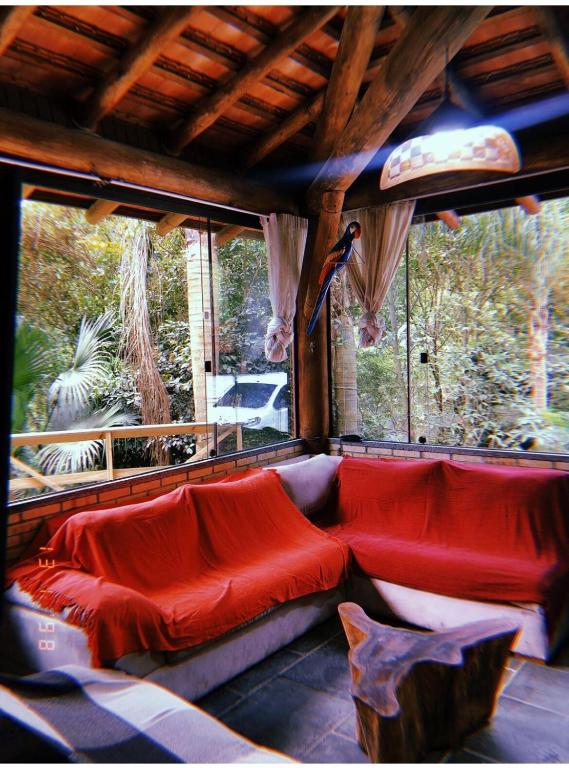 a red couch in a room with a window at Casa de campo in Itapema