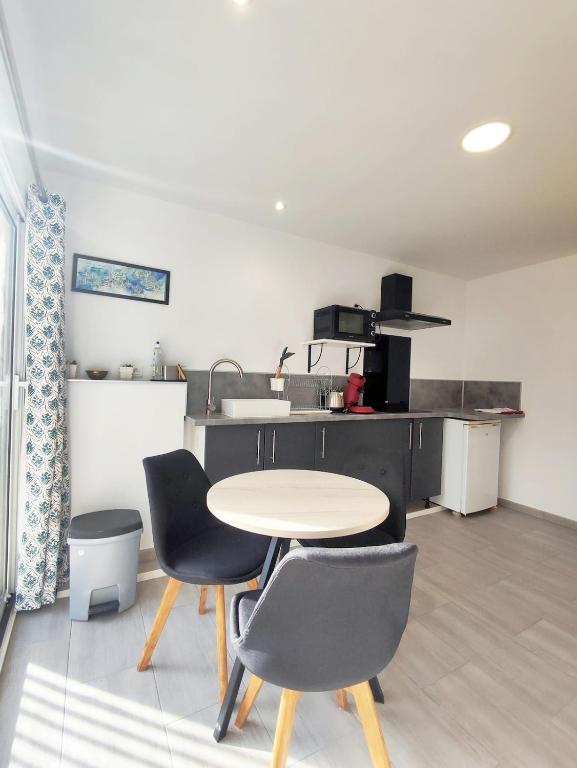 a kitchen with a table and chairs in a room at studio avec terrasse et parking privatif in Courthézon