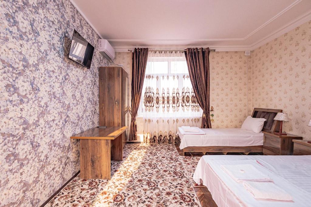 a hotel room with two beds and a window at Major Guest House in Fergana