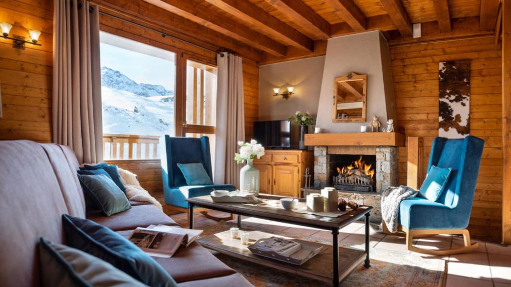 - un salon avec un canapé, des chaises et une cheminée dans l'établissement lesetoilesdelaplagne chalet 16 au pied piste a belle plagne, à La Plagne Tarentaise