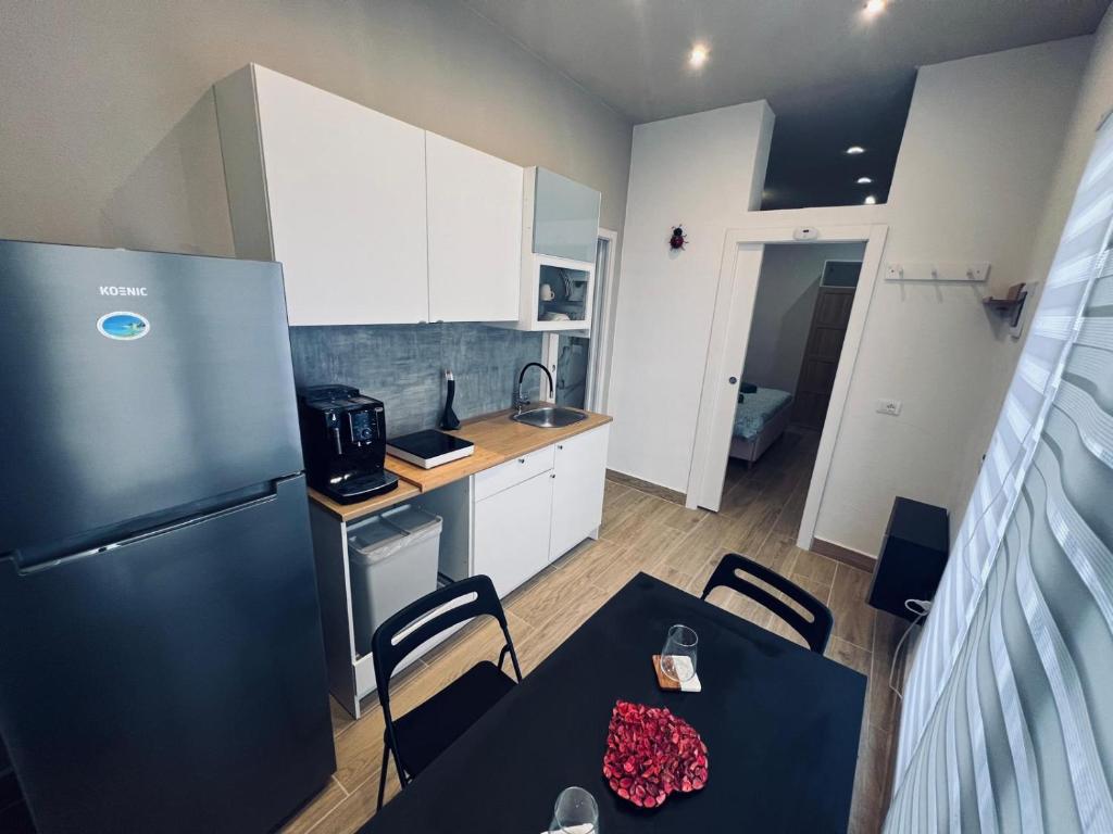 a kitchen with a black refrigerator and a table and chairs at King House B&B Catania in Catania
