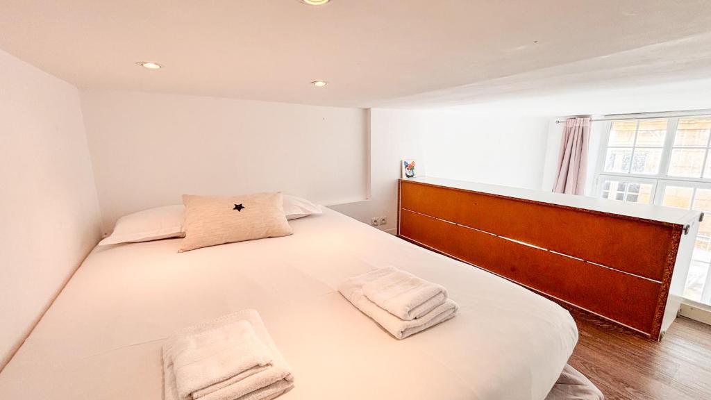 a bedroom with a large white bed with two towels at Historical center in apartment XVIII th century in Bordeaux