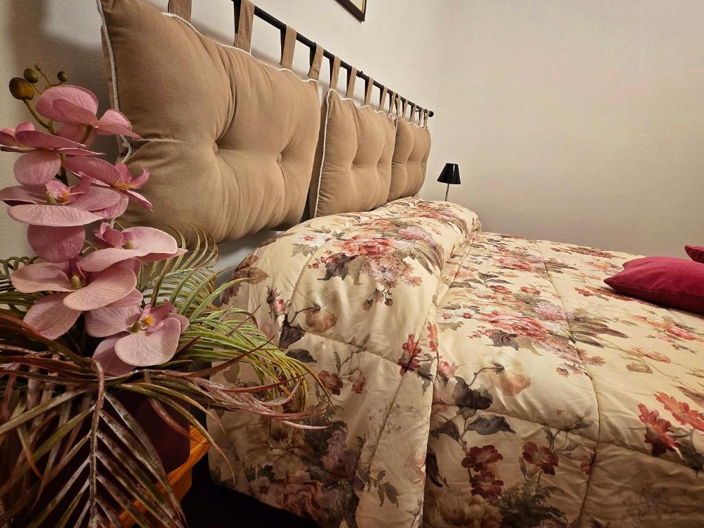 a bed with a bedspread with flowers on it at La Spiga di Grano in Piancastagnaio