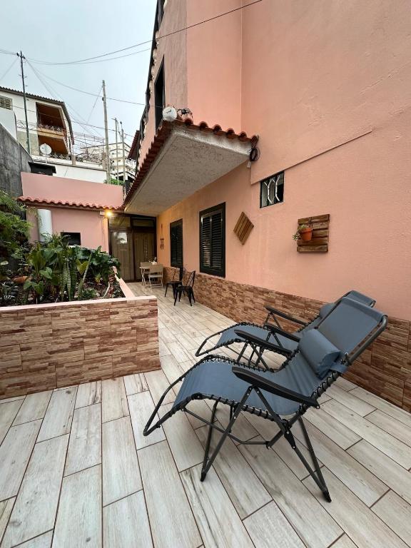 a chair sitting on a patio next to a building at Casa dos Andrés in Calheta