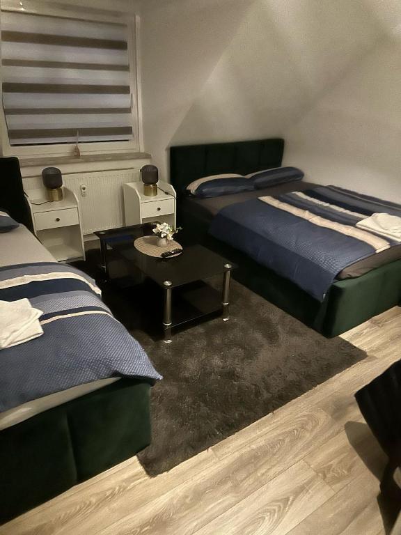 a bedroom with two beds and a coffee table at Ferienwohnung Centro 2 in Bremerhaven