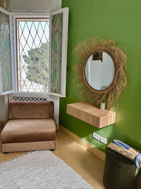 a green room with a mirror and a chair at Nomads Hostel Tunisia in Tunis