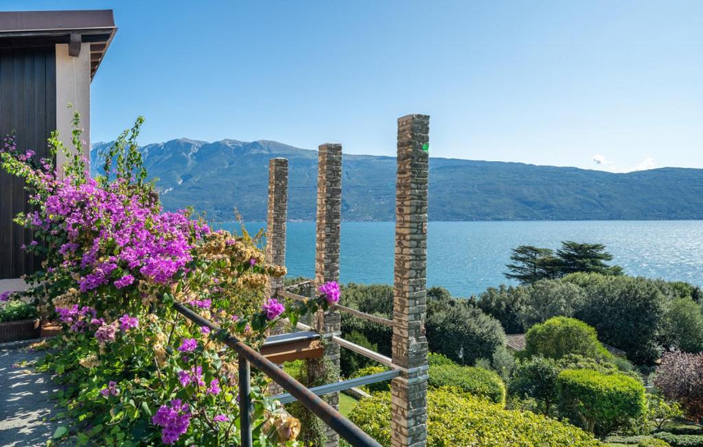 a garden with flowers and a view of the water at Casa Ileana in Gargnano