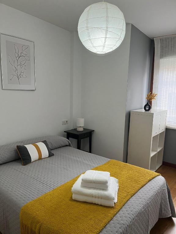 a bedroom with a bed with two towels on it at PISO Bueu Playa in Bueu