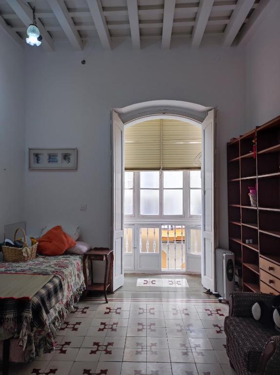a bedroom with a bed and a large window at Old Merchant's Home in Cádiz