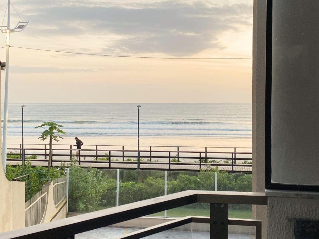 una vista de la playa desde el balcón de un edificio en Apartamento - Pé na Areia, en Itapema