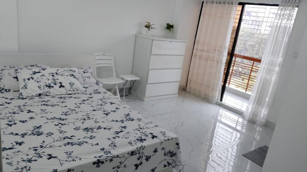 a bedroom with a bed and a dresser and a window at Airport Bliss Residence in Chandālbhog