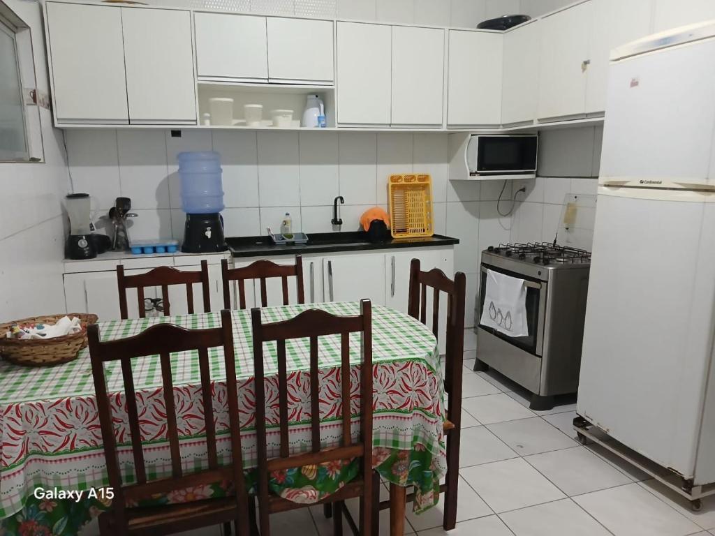 eine Küche mit Tisch und Stühlen und einem Kühlschrank in der Unterkunft Cantinho da bel in Maragogi