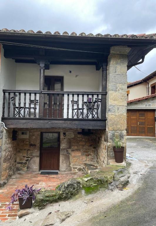 a house with a balcony on the side of it at Los Paxarinos in Vibaño
